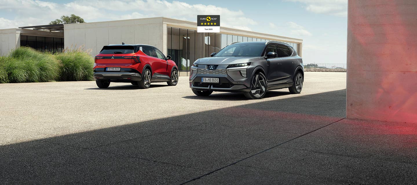 Foto: Rød og grå Eclipse Cross foran en bygning